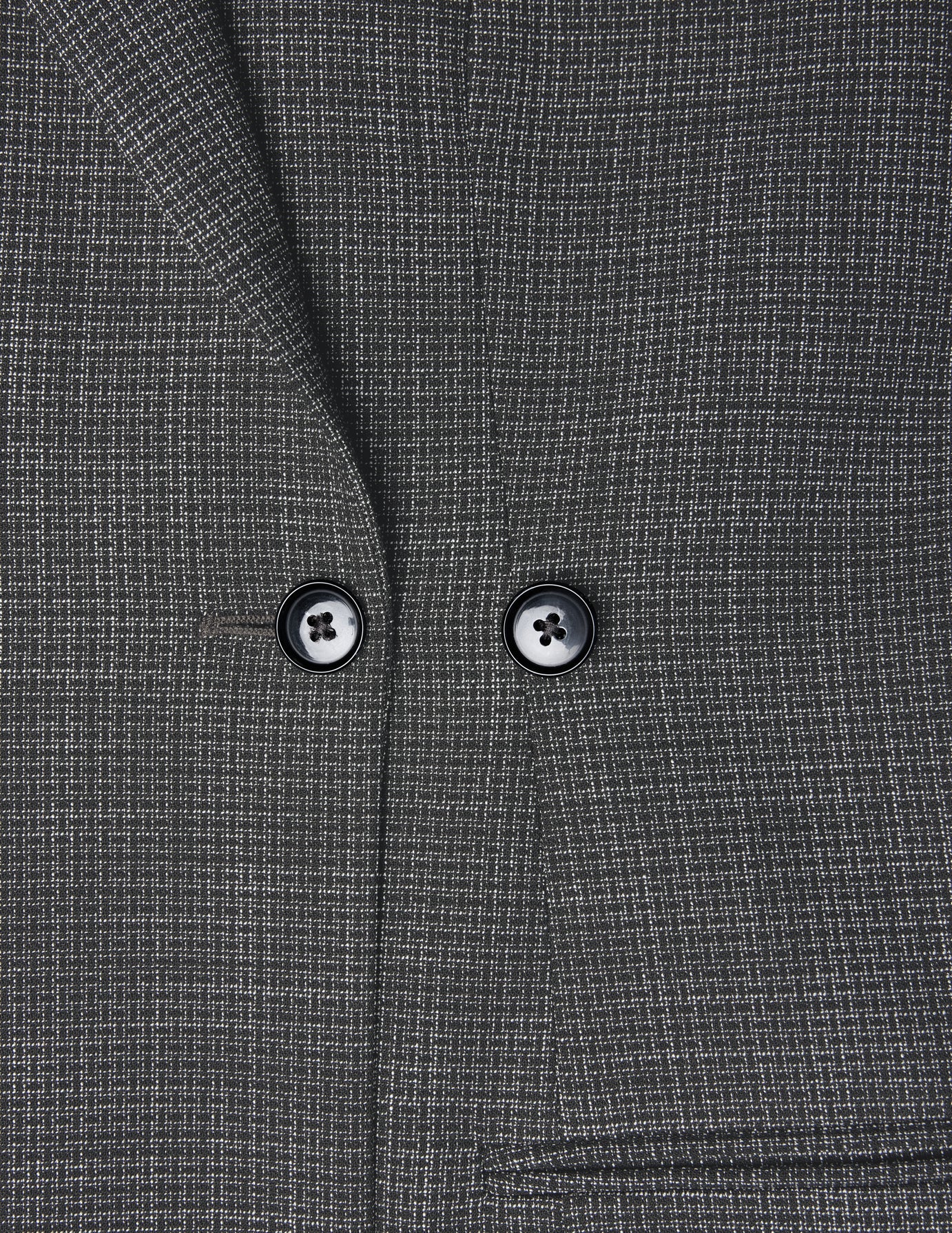 Nahaufnahme eines Women Nara Blazer Fitted Black Check – eines anthrazitfarbenen, taillierten Blazers mit dezentem weißem Karomuster, zwei schwarzen Knöpfen und 360°-Stretch.
